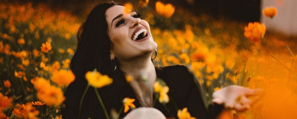 Lachende vrouw in een veld met bloemen