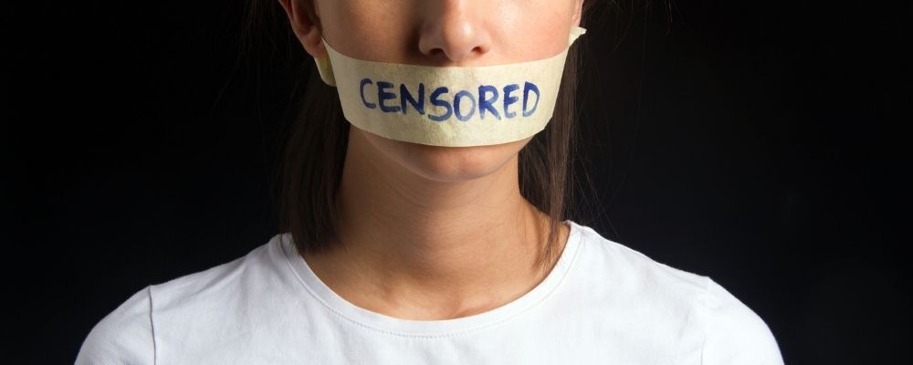 Vrouw met plakband op haar mond waarop censored staat geschreven