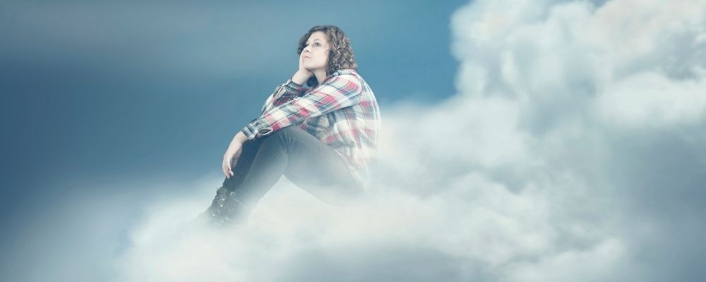 Vrouw denkt na terwijl ze op wolken zit