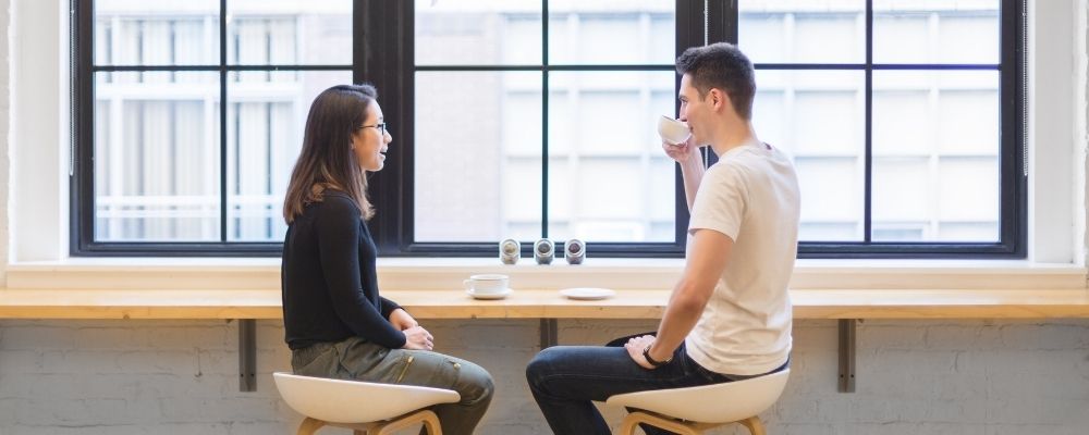 Man en vrouw zitten samen aan tafel en praten met elkaar
