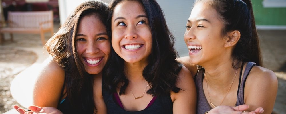 Drie meiden die samen lachen