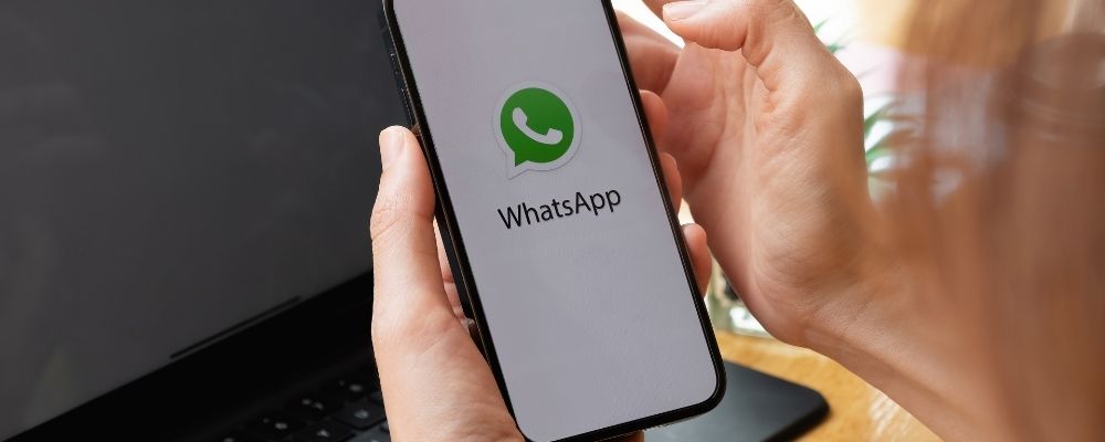 Persoon houdt telefoon vast met WhatsApp