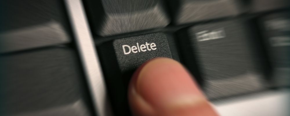 Persoon die met een vinger op de delete knopt drukt op een toetsenbord