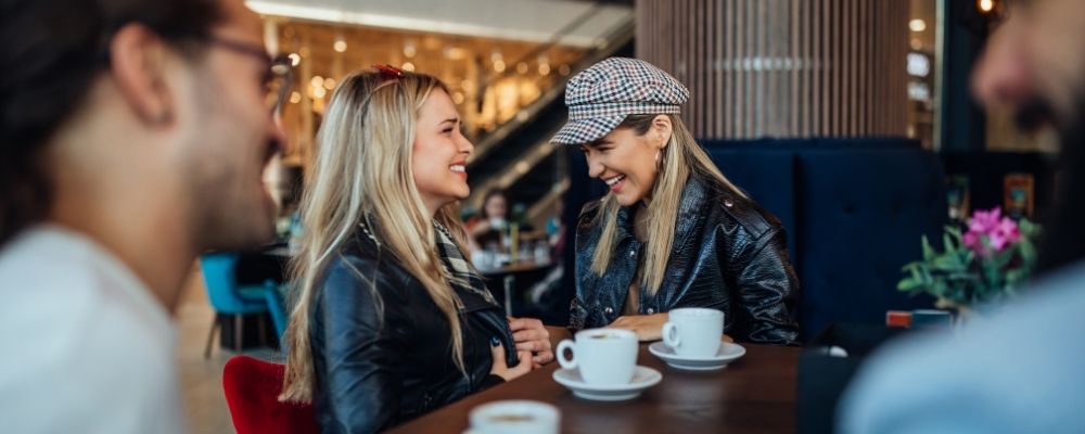 Twee vriendinnen die samen lachen in een café