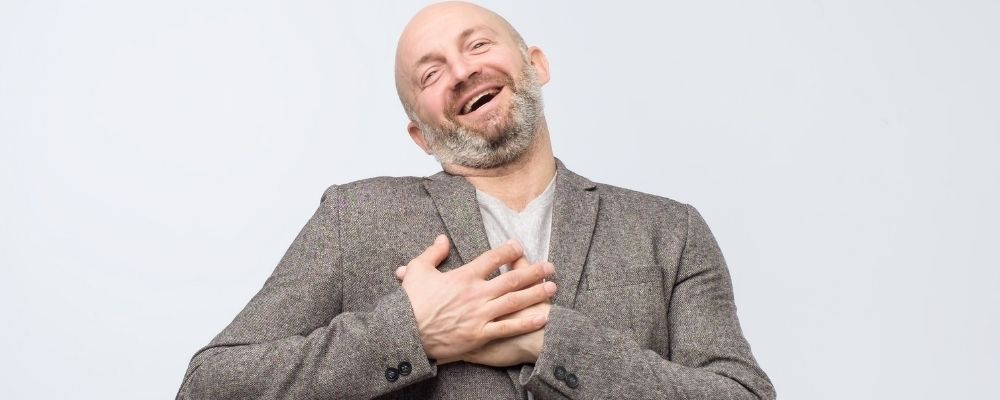 Man die zijn handen op zijn borst houdt en lacht - communiceren met narcist