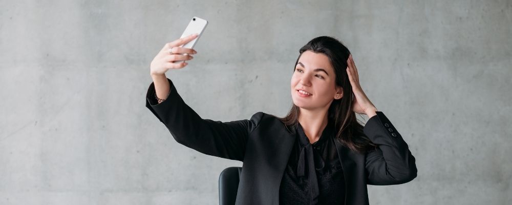 Vrouw die narcistisch naar zichzelf kijkt in haar telefoon camera