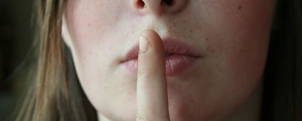 Vrouw die haar vinger tegen haar lippen duwt - Narcist negeren
