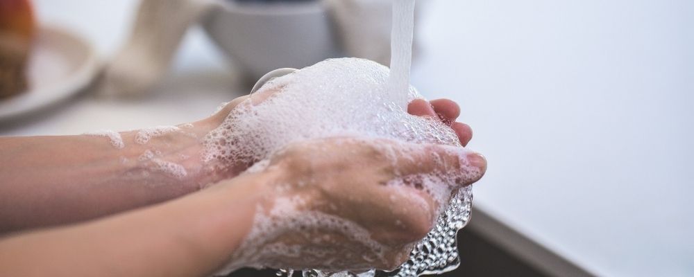 Persoon die zijn handen wast met zeep